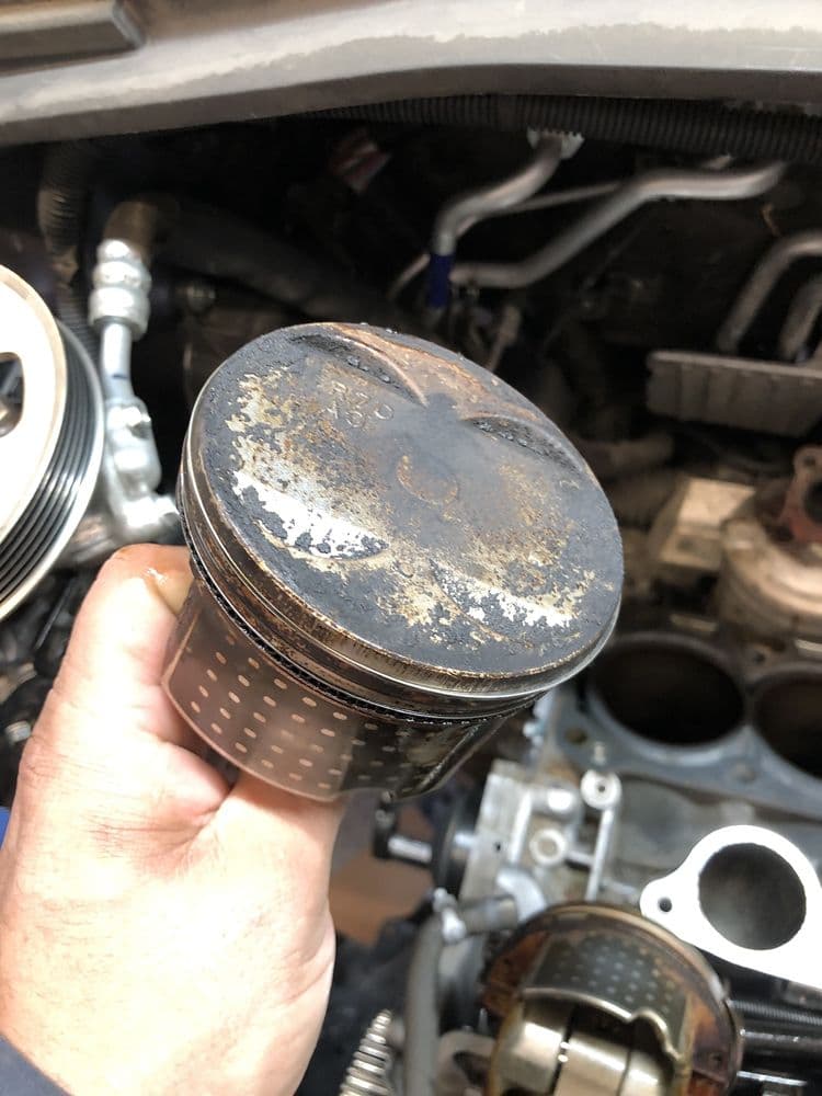 Mechanic inspecting a worn piston during engine diagnostics in Mount Vernon, WA