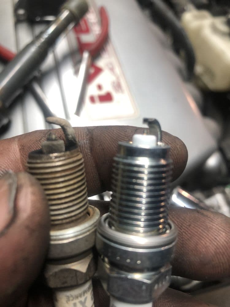 Old and new spark plugs compared during a tune-up in Mount Vernon, WA